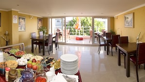 A dining area with a buffet setup, including plates of food, a fruit bowl, and various condiments. - Meddusa Hotel (Istanbul)