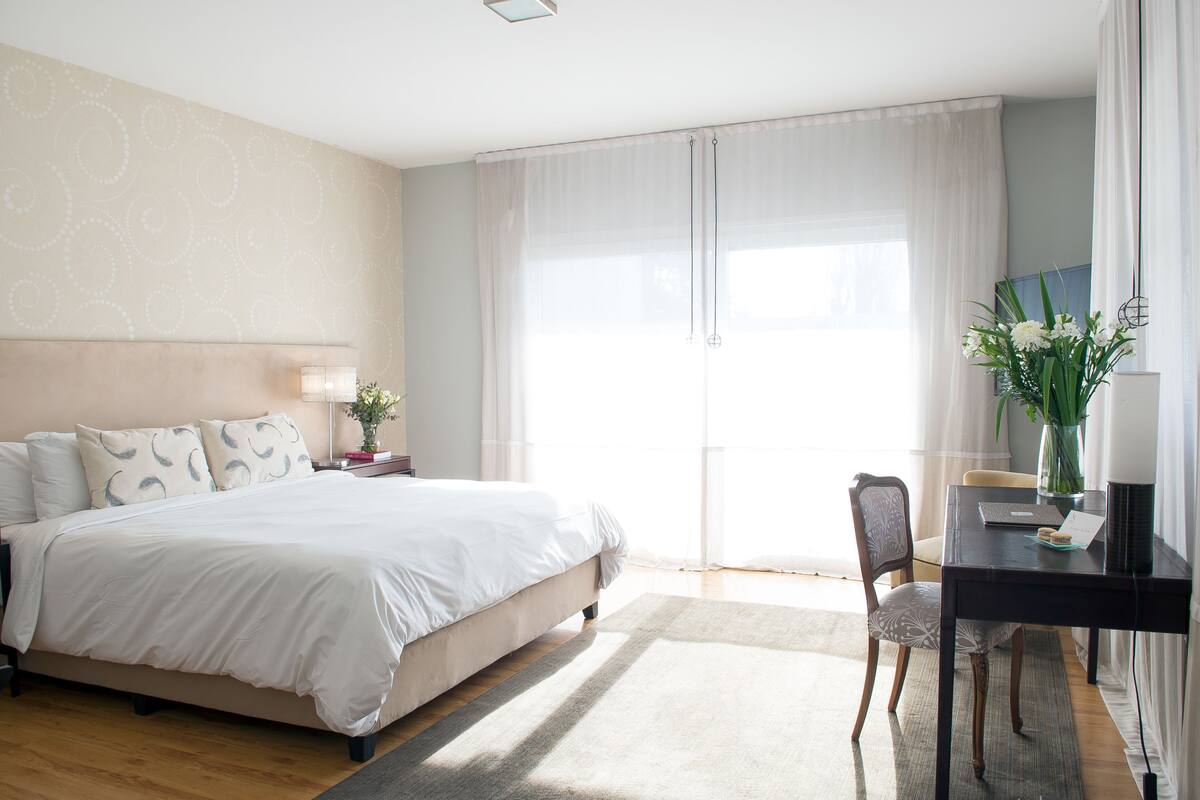 A bedroom with a bed, a desk, and a chair.