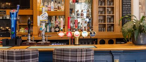 A bar area with multiple beer taps, a variety of liquor bottles, and a menu board.