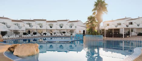 Una piscina al aire libre de temporada, sombrillas