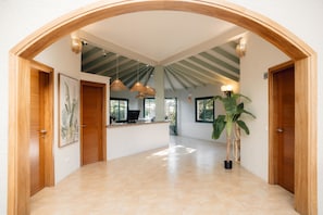Un vestíbulo amplio con techo alto, puertas de madera y mostrador de recepción.