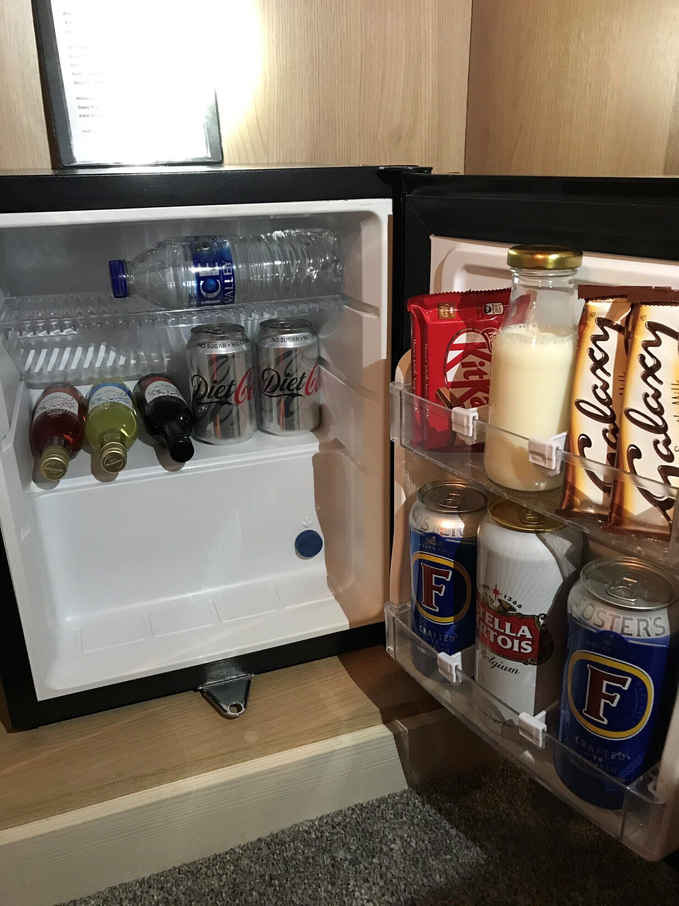 A refrigerator stocked with beverages and snacks.