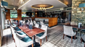 A modern restaurant with a bar area, wooden tables, and chairs. - Close House (Newcastle-upon-Tyne)