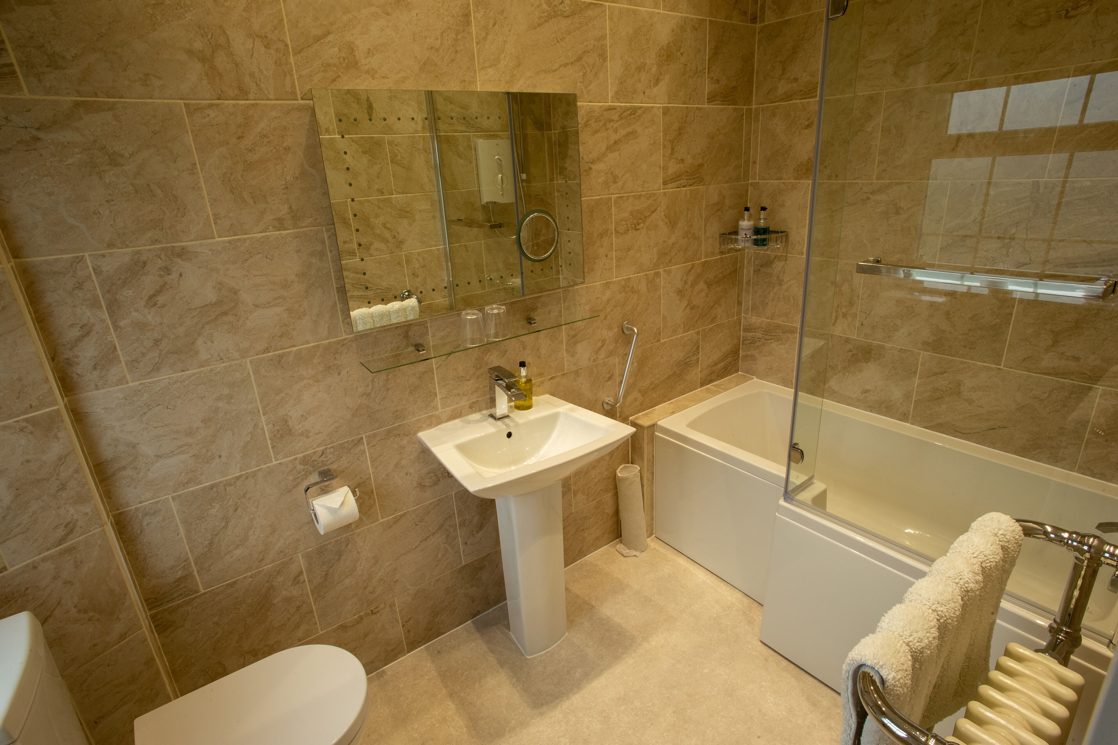 A modern bathroom with a white sink, a glass-enclosed shower, and a bathtub.