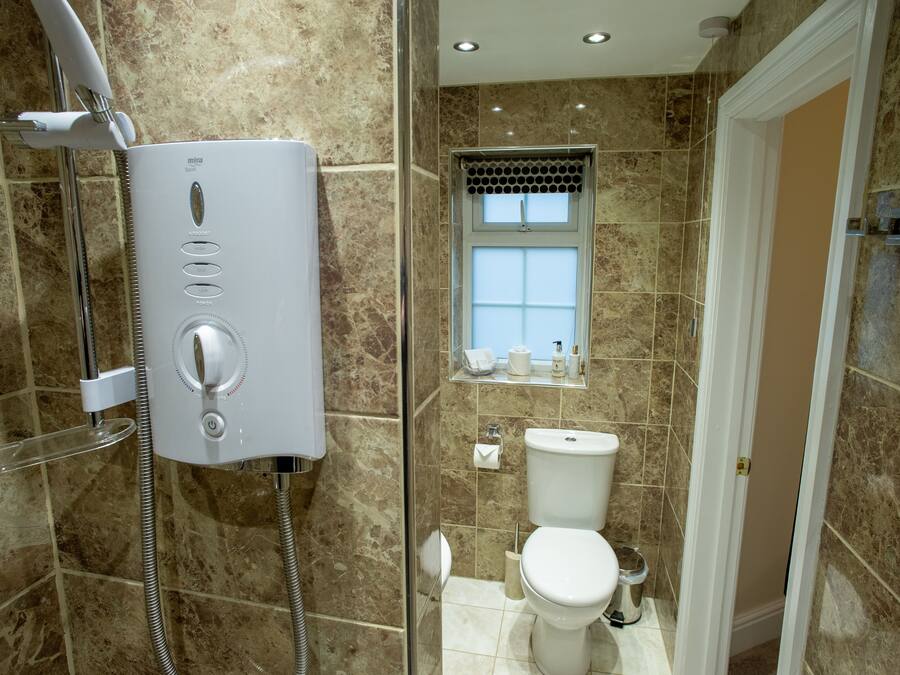 Ein Badezimmer mit Duschkabine, Toilette und Waschbecken.