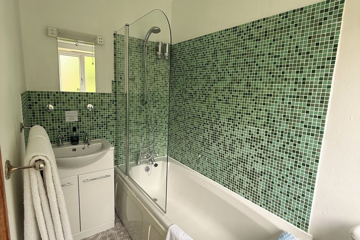 Une salle de bain avec une baignoire, un lavabo, un miroir et une douche.