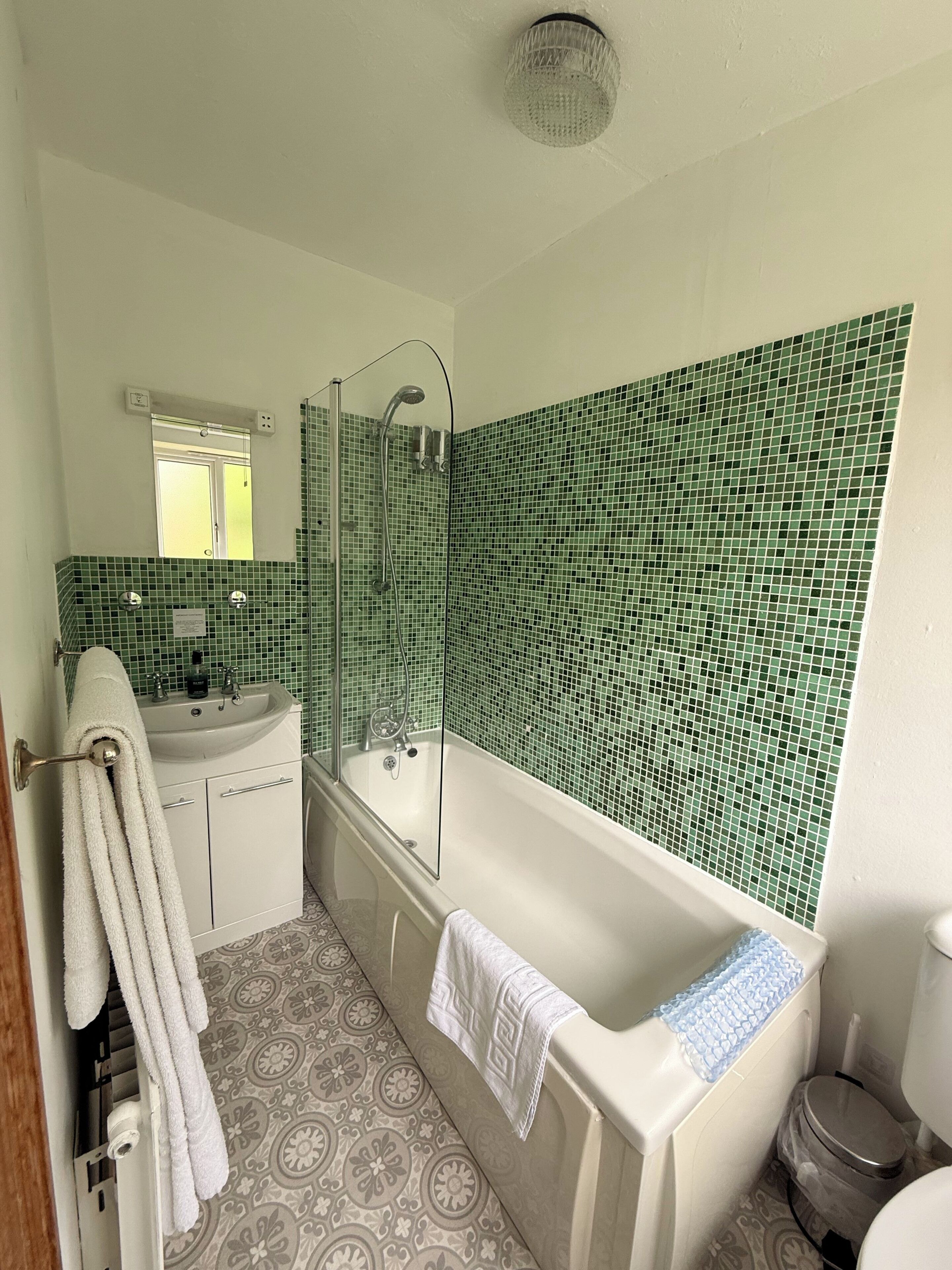 A bathroom with a bathtub, a sink, a mirror, and a shower.