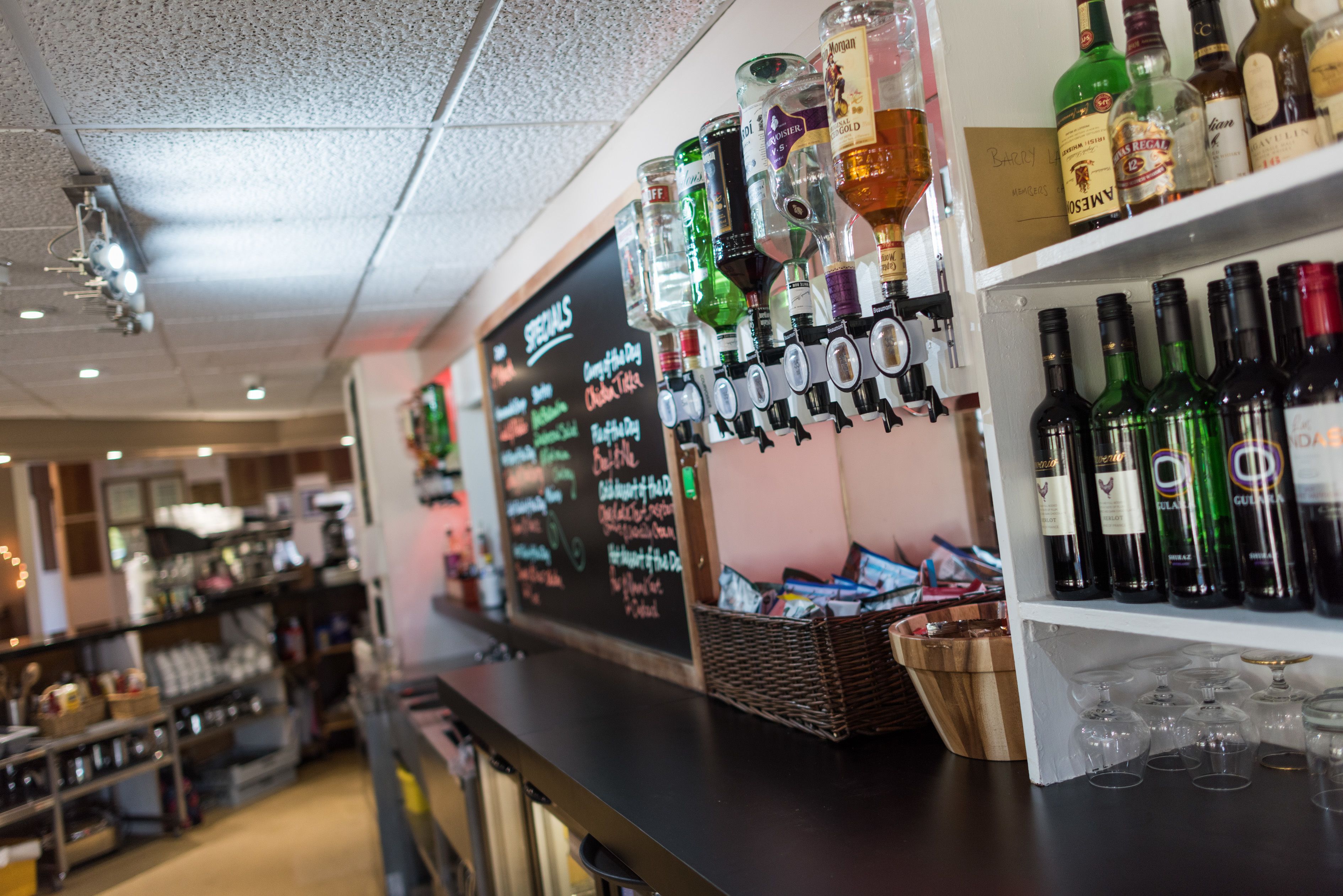 A bar area with shelves of liquor bottles and glasses.