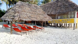 På stranden, hvit sand, solsenger og strandhåndklær