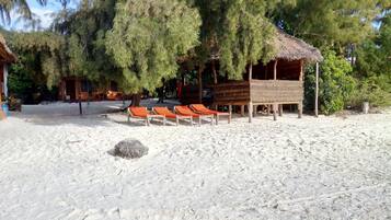On the beach, white sand, sun-loungers, beach towels