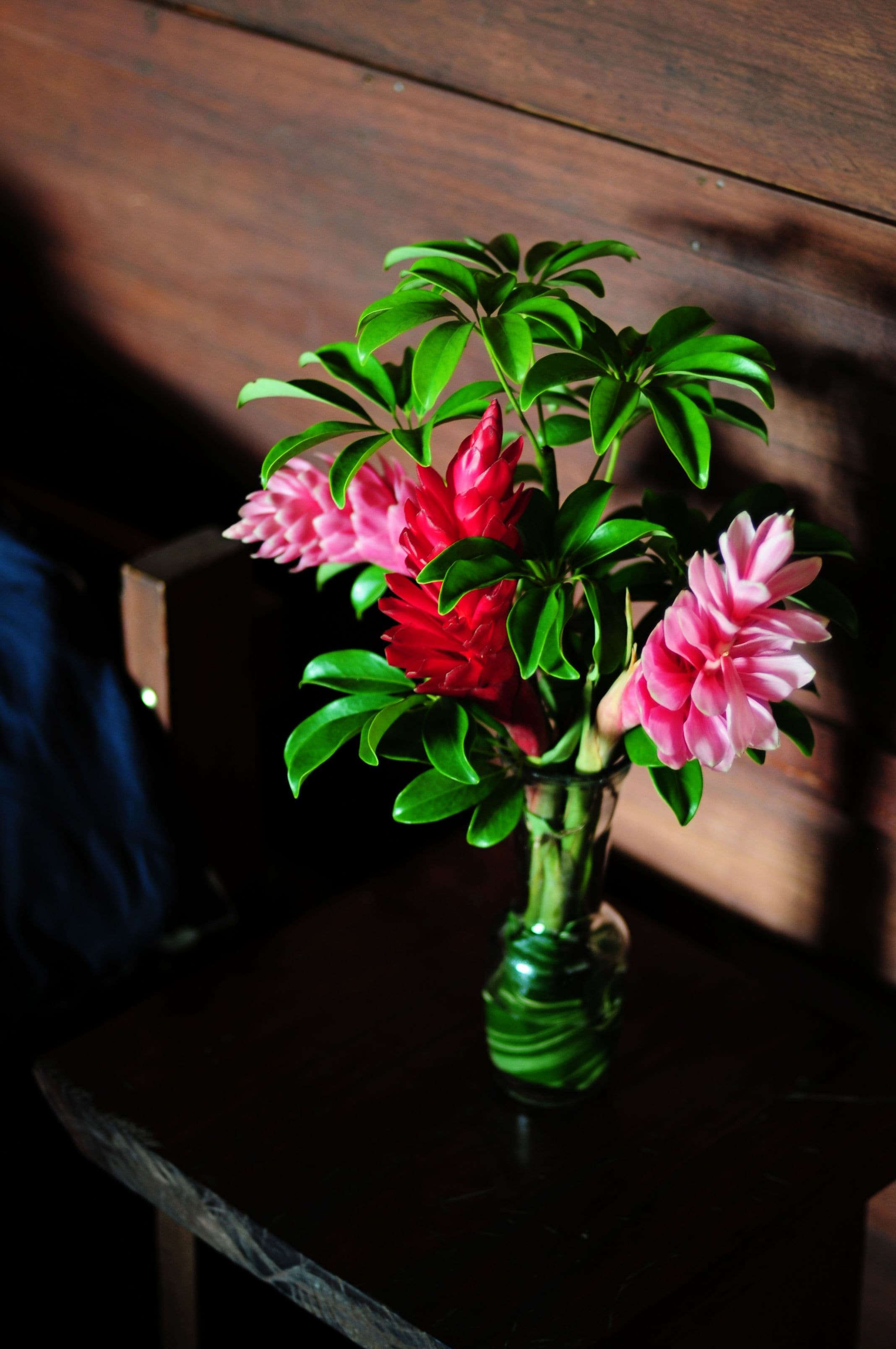 Un vase rempli de fleurs est posé sur une table en bois.