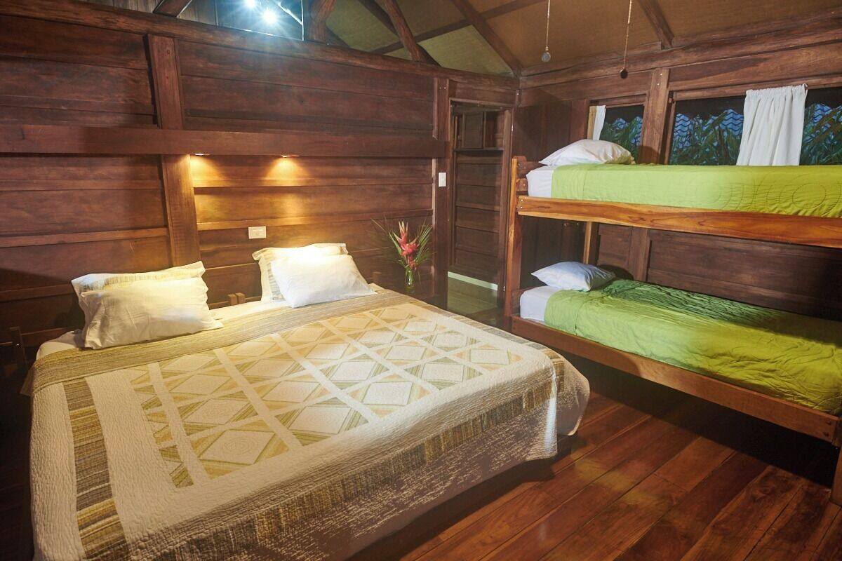 A wooden cabin bedroom with a bunk bed and a single bed.