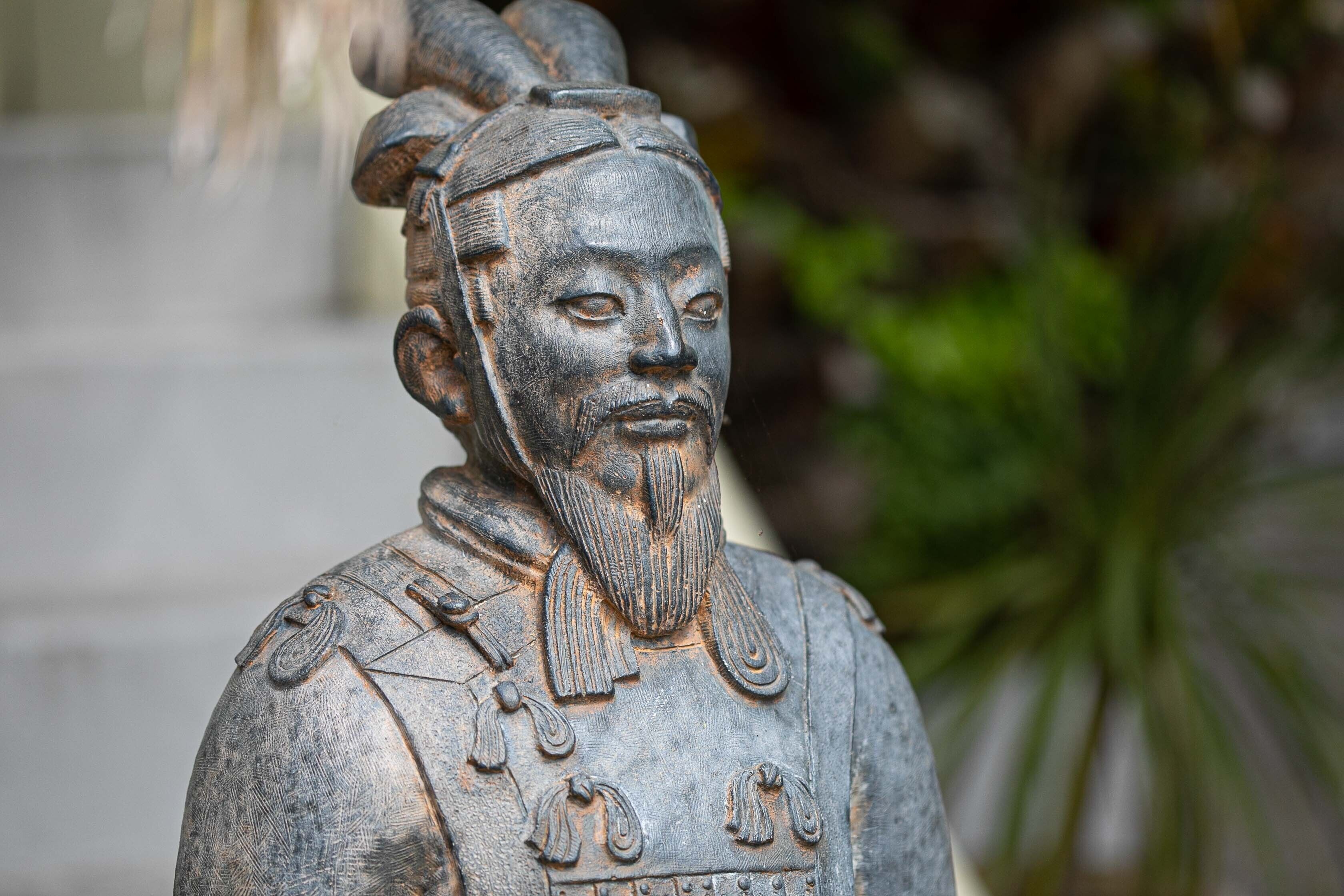 A statue of a historical figure with intricate carvings and a detailed headdress.