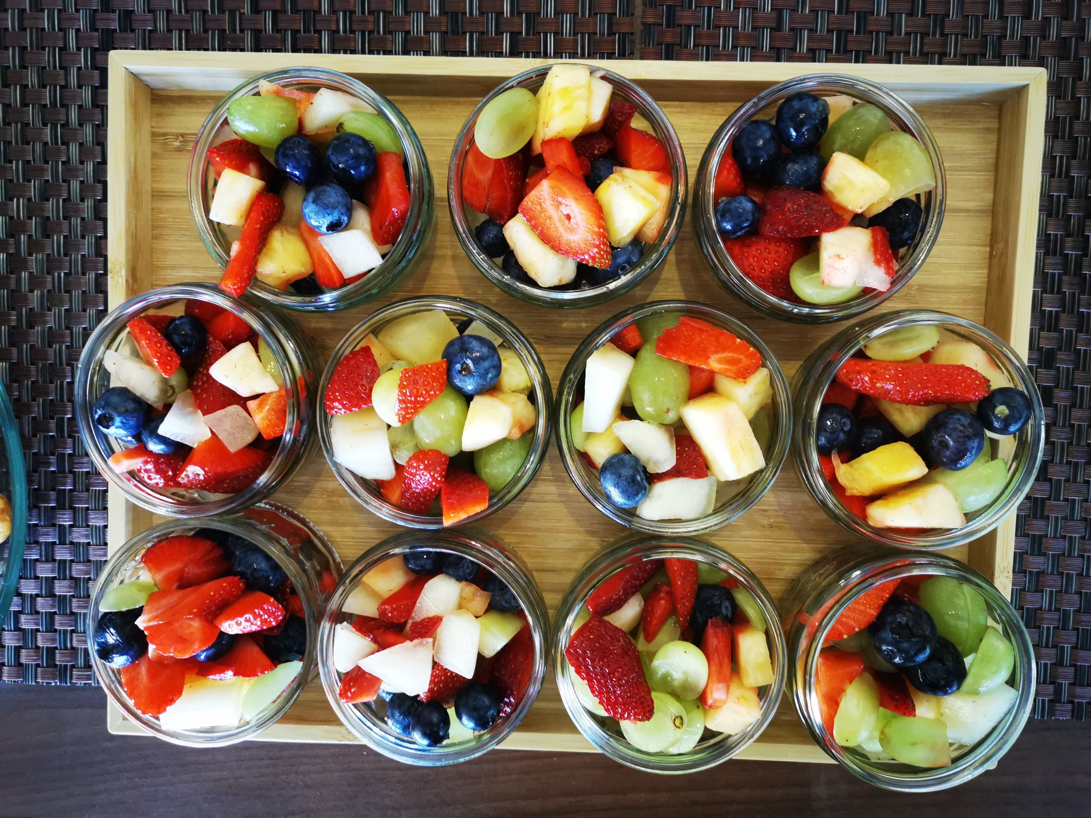 A tray with multiple glass bowls containing assorted fruits.