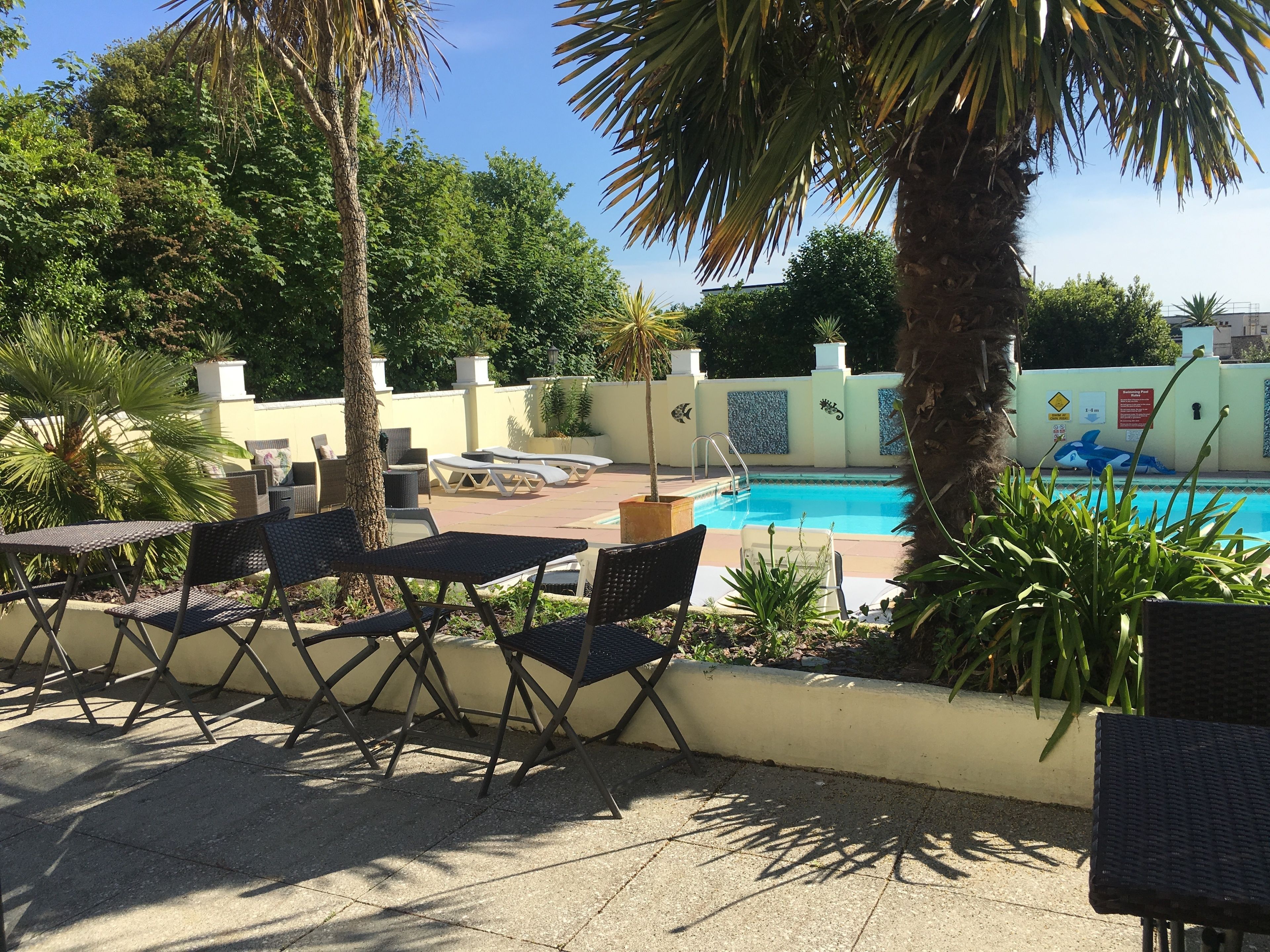 An outdoor pool area with lounge chairs and a poolside table.