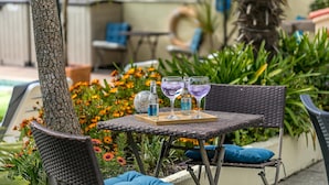 Un espacio al aire libre con mesa, sillas y una bandeja con bebidas.