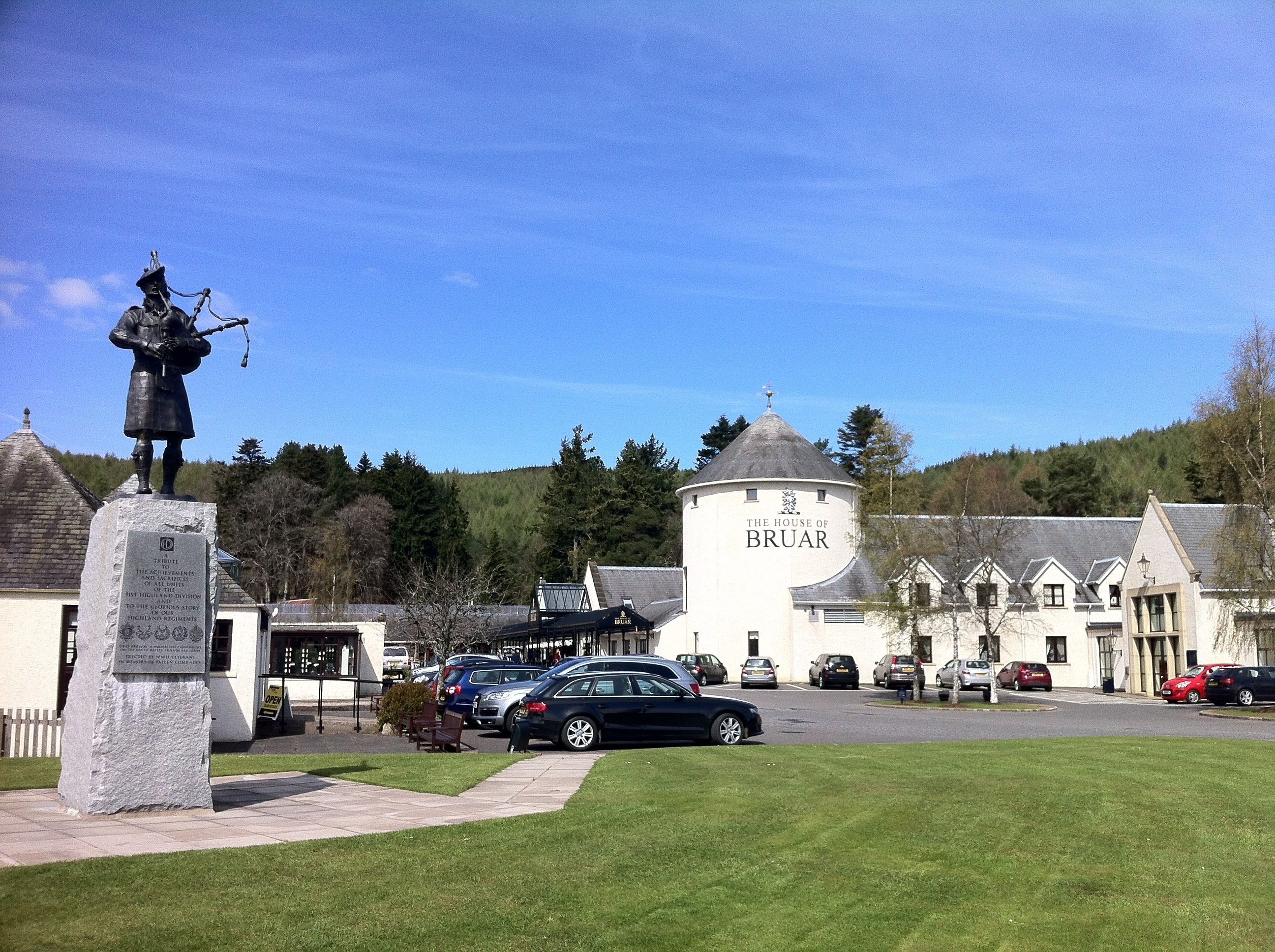 A statue of a historical figure, a white building labeled "The House of Bruar," and a parking lot with cars.