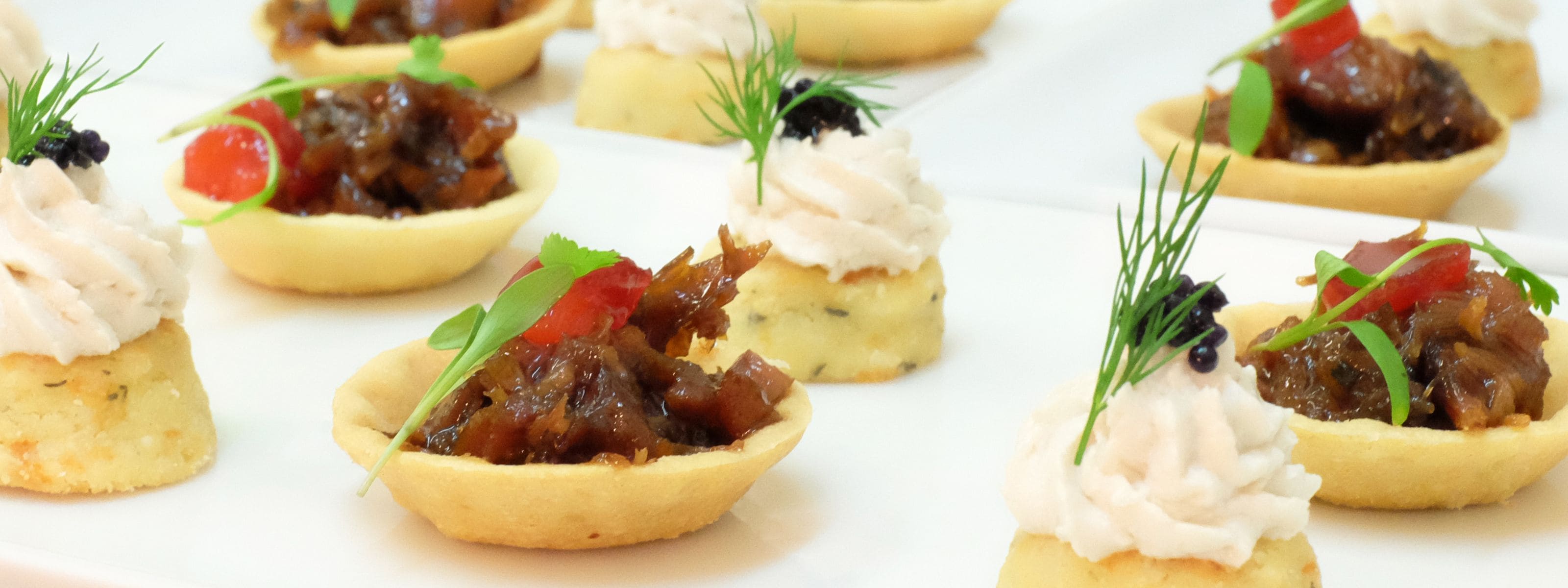 A variety of appetizers arranged on a white plate.