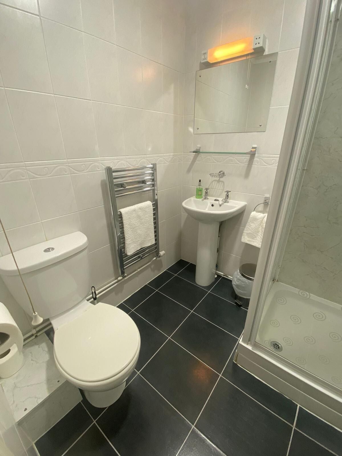 A bathroom with a toilet, sink, and shower.
