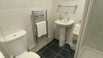 A bathroom with a toilet, sink, and shower.