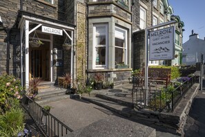 A corner building with a sign reading "MELROSE GUEST HOUSE VACANCIES". - Melrose Guest House (Ambleside)