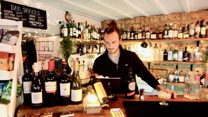 A bar with a variety of bottles and a menu board. - The Mousetrap Inn (Cheltenham)
