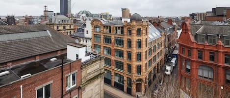 A cityscape with a mix of modern and historic buildings, including a prominent red brick building with a dome.