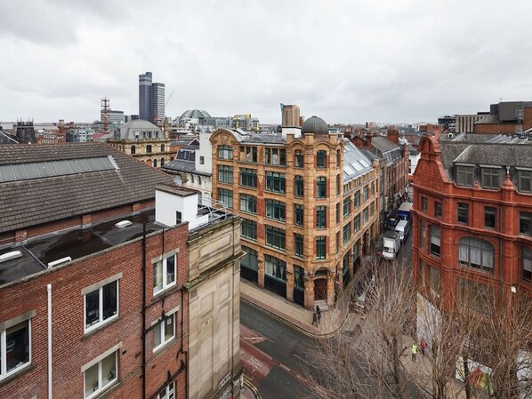 A cityscape with a mix of modern and historic buildings, including a prominent red brick building with a dome.