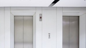 A modern elevator with a minimalist design, featuring a control panel and a digital display. - My-Places Serviced Apartments (Manchester)