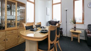 A modern kitchen with a round dining table, wooden chairs, and a glass cabinet with kitchenware. - My-Places Serviced Apartments (Manchester)