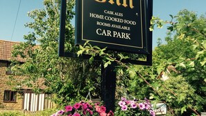 A sign for The New Inn, listing amenities like cask ales, home cooked food, available rooms, and a car park. - New Inn (Ilminster)
