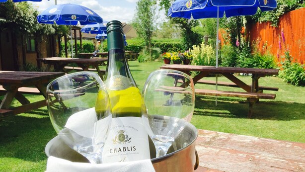 A wine bottle in a bucket with a label reading "CHABLIS" and two wine glasses. - New Inn (Ilminster)