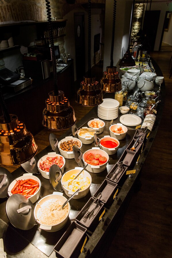 Una mesa de buffet con diversos alimentos y utensilios para servir.