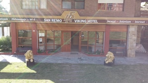 The exterior of the San Remo Viking Hotel with a signboard indicating amenities like Wi-Fi, Jacuzzi, and internet. - San Remo Viking Hotel (Pinamar)