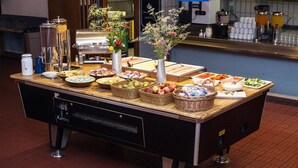 Montaje de bufé con diversos alimentos y una estación de café.
