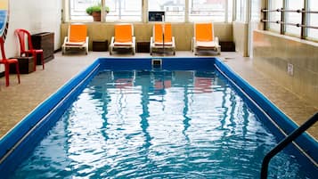 Una piscina techada, sillones reclinables de piscina