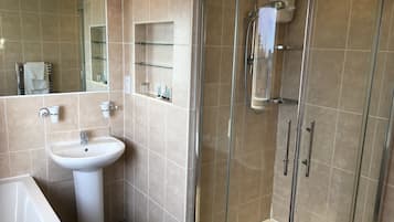 A modern bathroom with a glass-enclosed shower, a white sink, and a mirror.