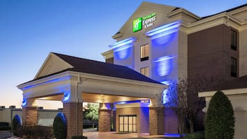 Edificio de Holiday Inn Express & Suites con entrada cubierta y cielo despejado.