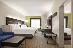 A hotel room with a bed, a desk, a chair, a sofa, and a TV.