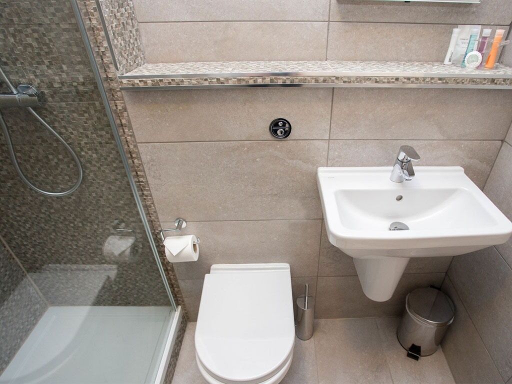 A bathroom with a toilet, sink, and shower.