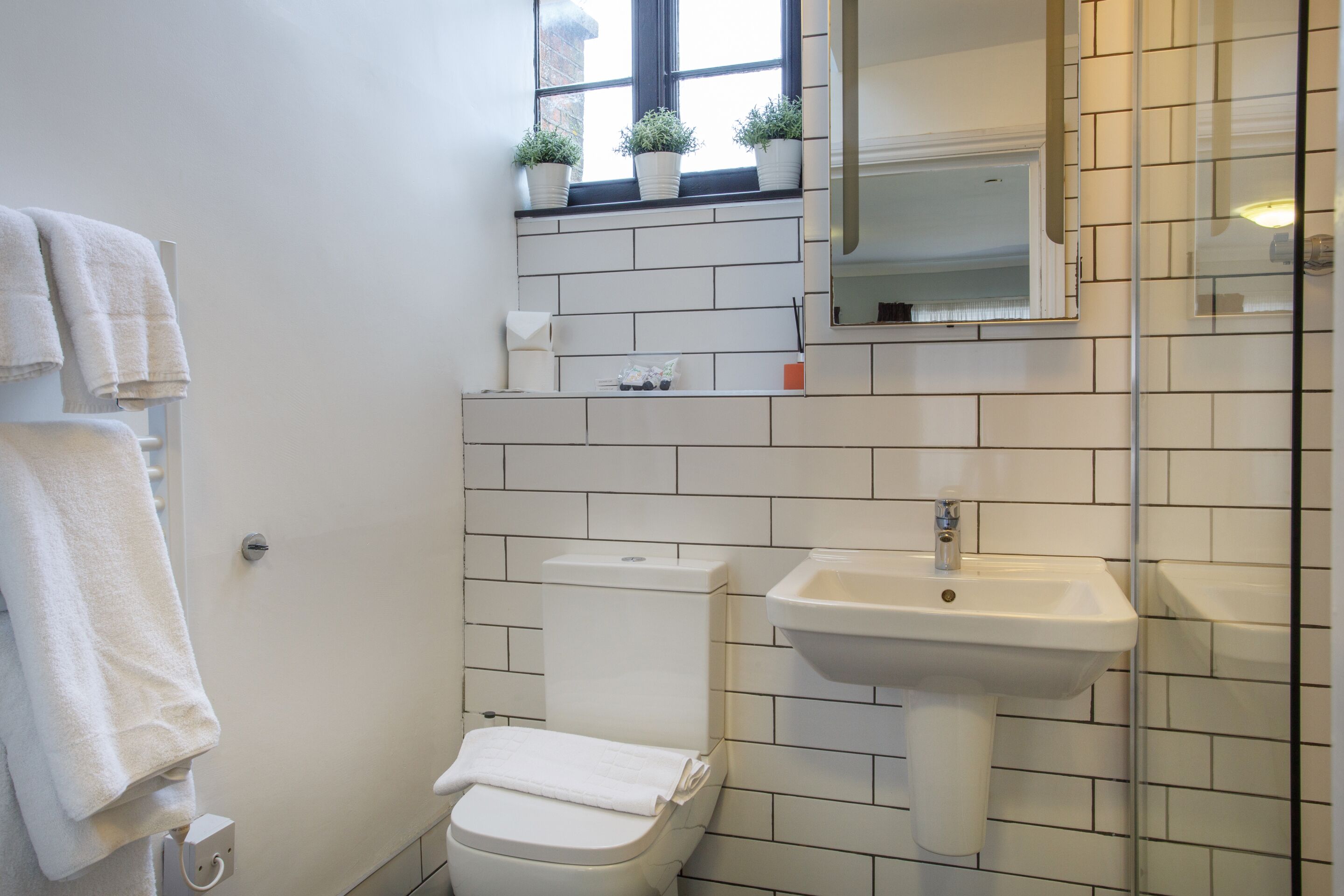 Een badkamer met toilet, wastafel en handdoekhouder.