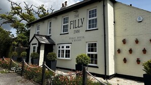 The Filly Inn, a public house with a traditional facade, featuring a signboard and a small entrance with a porch. - The Filly Inn (Brockenhurst)