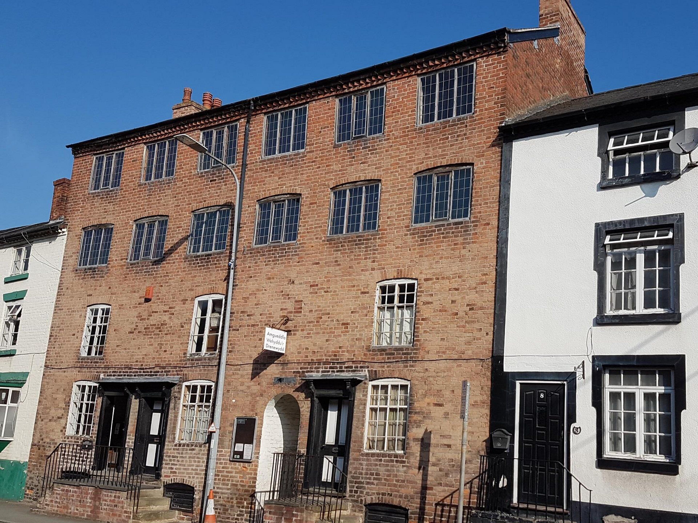 Un edificio de ladrillo de varios pisos con varias ventanas y un letrero que indica que es un pub.