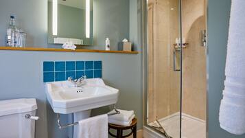 A bathroom with a sink, mirror, and shower.