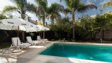 Alberca al aire libre por temporada y sombrillas en la alberca