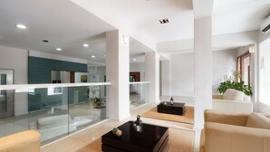 A modern living room with a glass partition, a black coffee table, beige sofas, and a teal accent wall. - Gran Hotel Brisas del Hum (Mercedes)