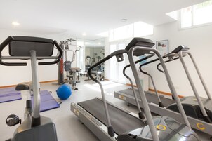A gym with treadmills, exercise balls, and various fitness equipment.