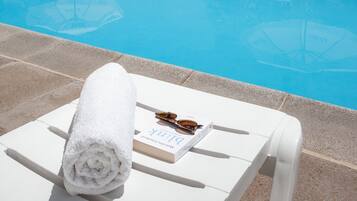 Alberca al aire libre y camastros