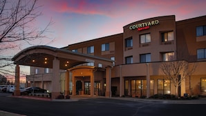 A Courtyard Marriott hotel with a covered entrance, multiple windows, and a parking lot.