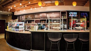 A bar area with a counter, menu boards, and bar stools.